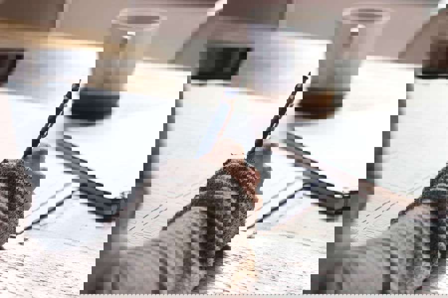 A person holding a pencil and drawing diagrams at a wooden table