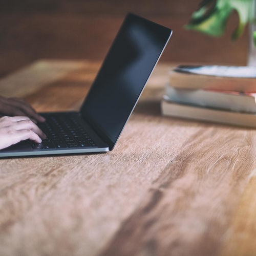Hands typing on a laptop