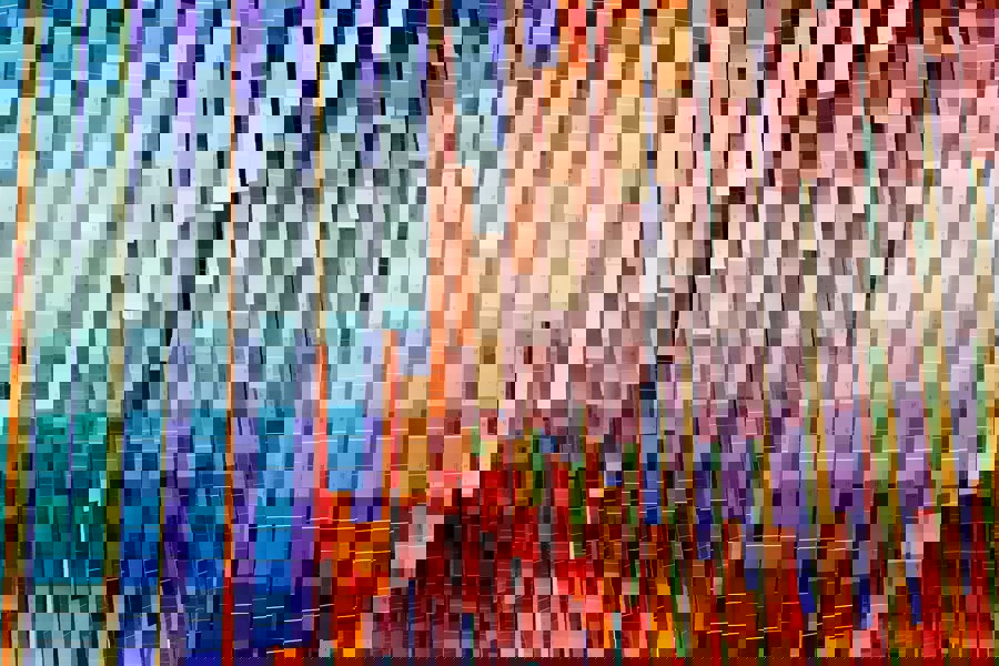 An artistic installation of multiple colours on long strips hanging from the ceiling. 